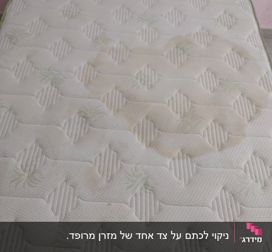 ניקוי לכתם על צד אחד של מזרן מרופד.